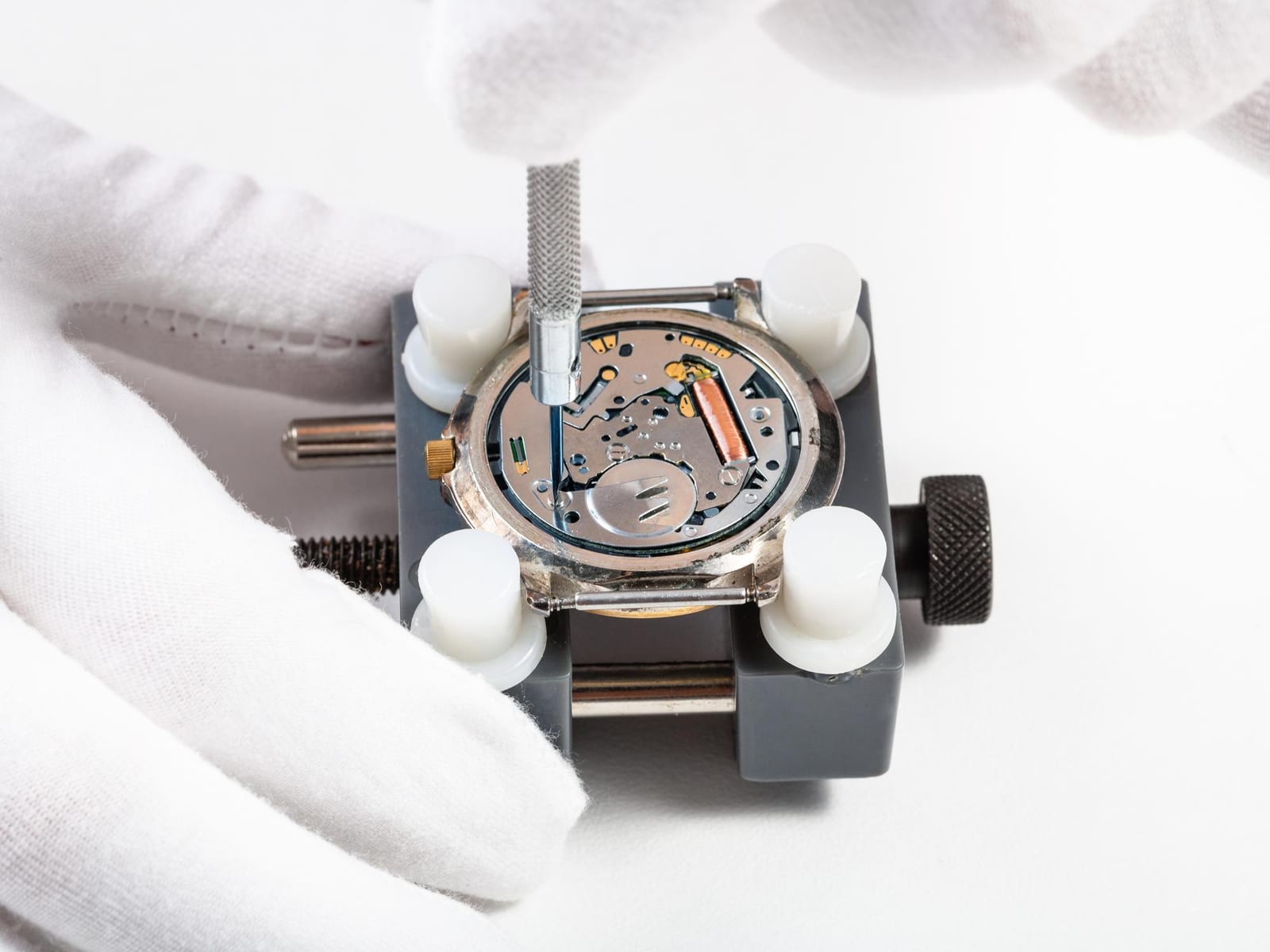 Verifica al banco con lente d'ingrandimento di un orologio digitale, laboratorio Ruota Grigia